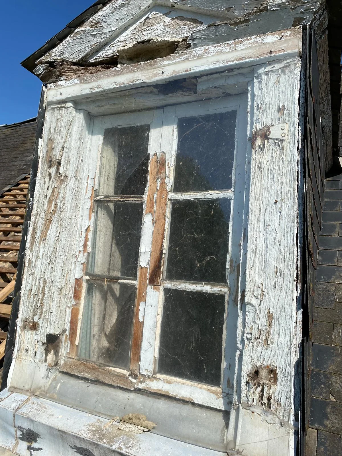 Menuiserie et bois très dégradés d’une lucarne ancienne